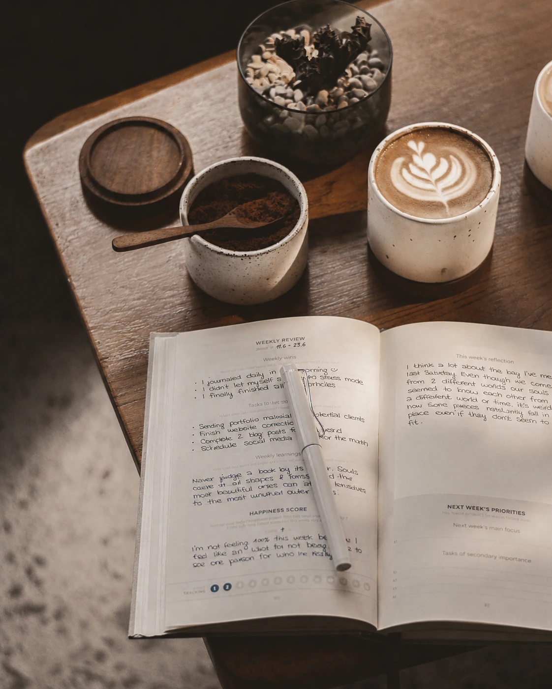 Café y journal abierto sobre una mesa de madera